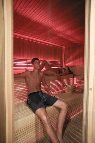 a man sitting on a bed in a room at Filoxenia Hotel & Spa in Kalavrita