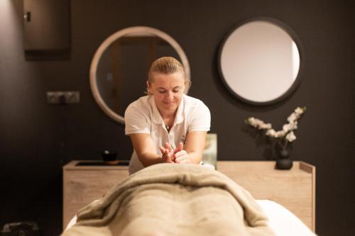 a woman in front of a table with a towel at Filoxenia Hotel & Spa in Kalavrita