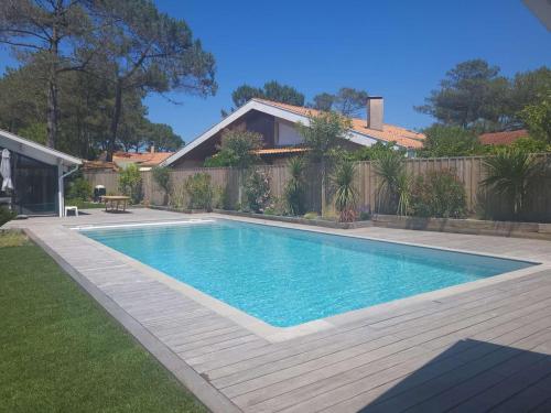 une piscine dans l'arrière-cour d'une maison dans l'établissement Biscarrosse Plage Villa avec piscine pour 12 personnes, à Biscarrosse-Plage