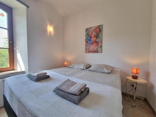 - 2 lits dans une chambre blanche ornée d'une peinture murale dans l'établissement La Roche 6, à Aigues-Vives