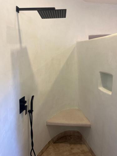 a white bathroom with a bench and a light at Villas Cononda in La Majahua