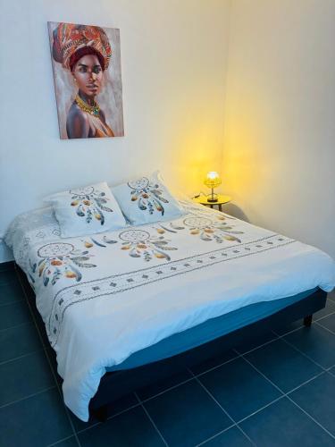 una cama en una habitación con un cuadro en la pared en L OREE DU BOIS, en Cayenne