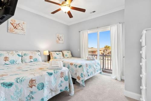 ein Schlafzimmer mit zwei Betten und einem Deckenventilator in der Unterkunft Blue Diamond by Pier 42 Vacations Oceanfront Luxury for 30 Guests in Holden Beach