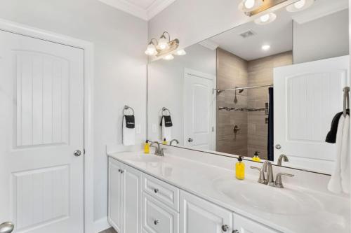 ein Badezimmer mit zwei Waschbecken und einem großen Spiegel in der Unterkunft Blue Diamond by Pier 42 Vacations Oceanfront Luxury for 30 Guests in Holden Beach