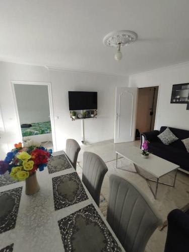 un salon avec une table, des chaises et un canapé dans l'établissement Appartement T4, à Sevran