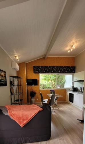 un salon avec un canapé noir et une cuisine dans l'établissement La Bruga, à Saint-Vincent-de-Tyrosse