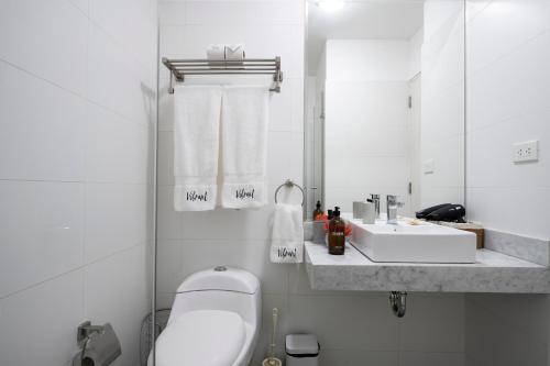 a white bathroom with a sink and a toilet at Connect Studios by Vibrant in Lima