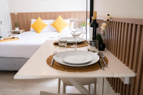 a white table with a plate and wine glasses on it at Connect Studios by Vibrant in Lima