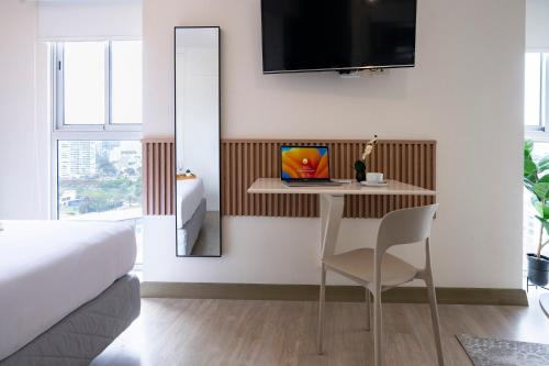 a bedroom with a bed and a table with a chair at Connect Studios by Vibrant in Lima
