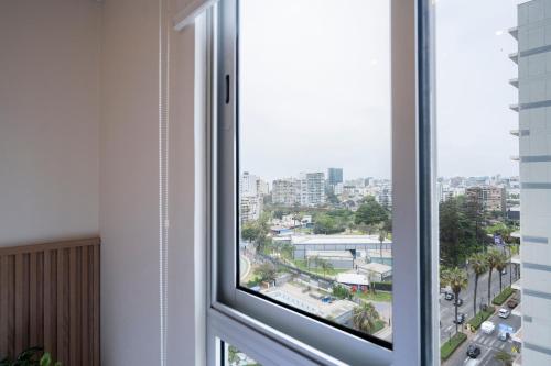 a window with a view of a city at Connect Studios by Vibrant in Lima