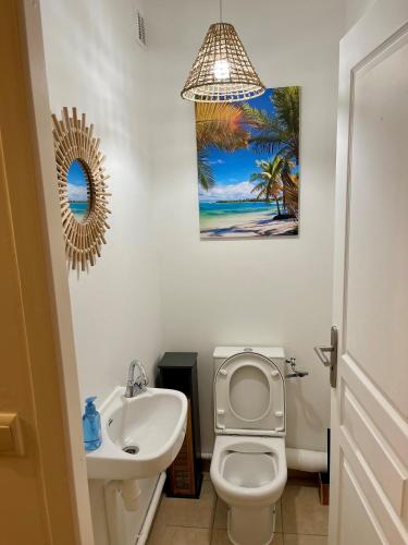 a bathroom with a white toilet and a sink at Nemo sur mer in Petit-Bourg