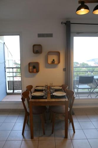 une salle à manger avec une table et des chaises et un balcon dans l'établissement Collioure Vue Mer Parking Gratuit Fibre, à Collioure