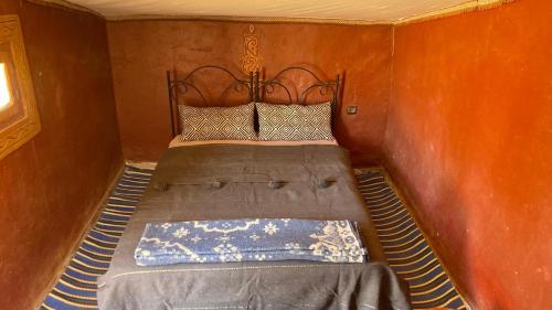 a bed in a corner of a room with at Sahara Camp Light in Mhamid