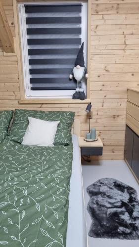 a bedroom with a bed and a window with a cat toy at Roubenka Olešná na Moravě in Olešná