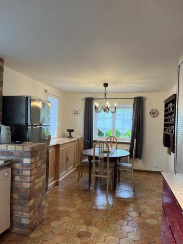 une cuisine avec une table et une salle à manger dans l'établissement La Maison dans le jardin du Manoir de Bouron, à Moigny
