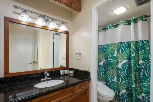 a bathroom with a sink and a toilet and a mirror at HEART of WAIKIKI,1BDRM,FREE PARKING, WIFI,NO RESORT FEES,YOUTUBE,NETFLIX ! in Honolulu