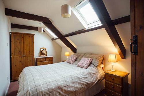 a bedroom with a bed with two pillows and a window at Birch Cottage - Tranquil Country Cottage with Indoor Swimming Pool in Haverfordwest