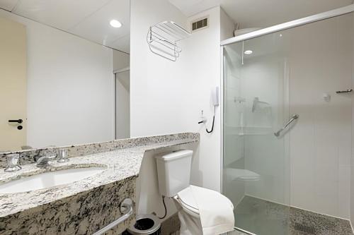 a bathroom with a toilet and a sink and a shower at Flats Osasco Trade Center in Osasco
