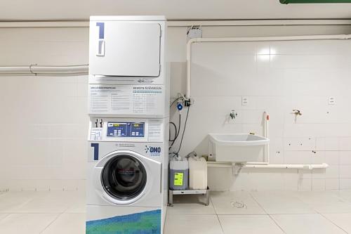 a washing machine in a white room with a sink at Flats Osasco Trade Center in Osasco