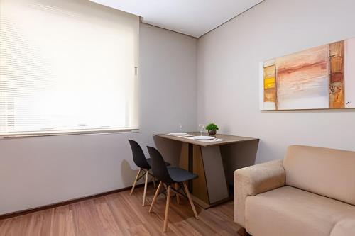 a living room with a couch and a table and chairs at Flats Osasco Trade Center in Osasco