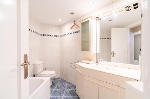 a white bathroom with a toilet and a sink at Playa Muchavista Terraza Vista Mar in La Venteta