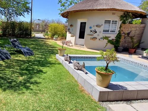 a backyard with a swimming pool and a house at Kruger Huisie Parys in Parys