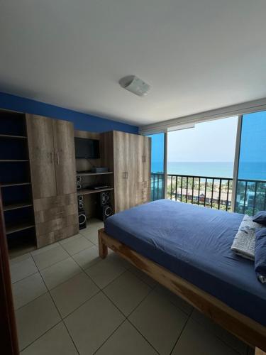 a bedroom with a bed and a view of the ocean at Departamento Punta Centinela frente al mar in Santa Elena
