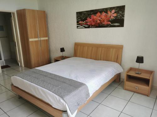 a bedroom with a large bed and two night stands at Le Dattier in Flic-en-Flac
