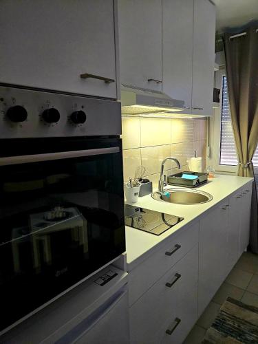a kitchen with a stove top oven next to a sink at TIHA VODA 4 in Požarevac