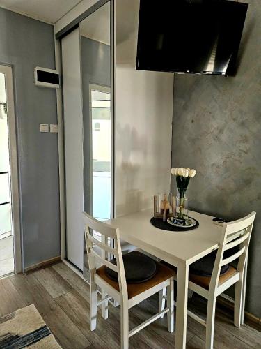 a dining room with a white table and chairs at TIHA VODA 4 in Požarevac