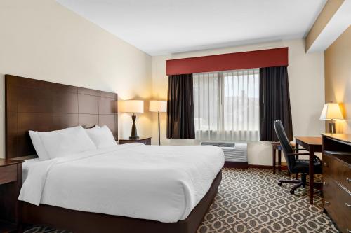 a hotel room with a large bed and a desk at Best Western Paradise Inn in Savoy