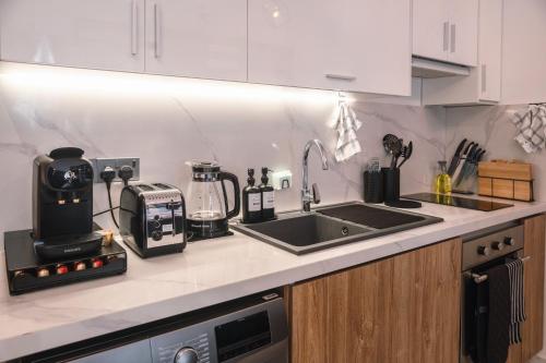 a kitchen with a sink and a counter top with a coffee maker at Luxury Studios by Home in Mpehuasem