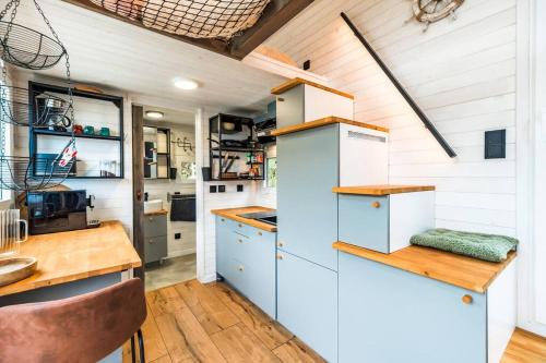 Il comprend une cuisine avec des placards blancs et du parquet. dans l'établissement Jacuzzi Tiny-House face mer Evasion sur la falaise, à Trévou-Tréguignec