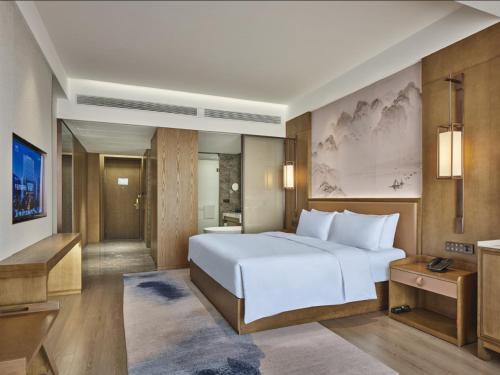 a bedroom with a large white bed and a bathroom at Crowne Plaza Chengdu Wuhou by IHG in Chengdu