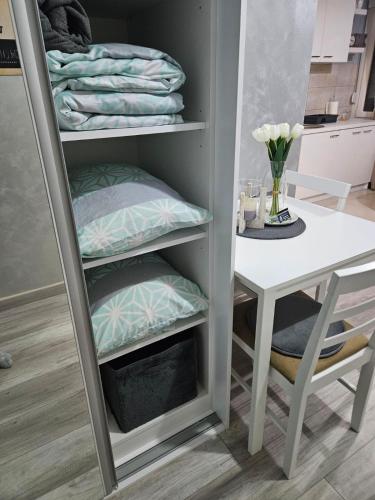 a room with a table and a shelf with towels at TIHA VODA 4 in Požarevac