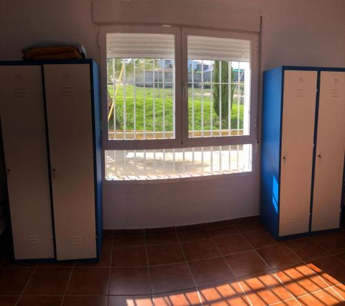 a room with a window and two lockers at Albergue Peregrinos El Carrascalejo in El Carrascalejo