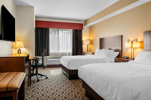 a hotel room with two beds and a desk at Best Western Paradise Inn in Savoy