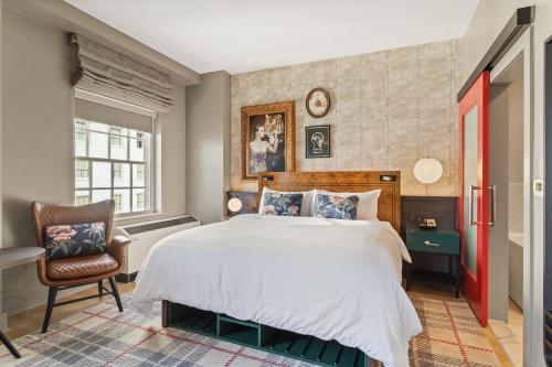 a bedroom with a large bed and a chair at Hotel Indigo Baton Rouge Downtown by IHG in Baton Rouge