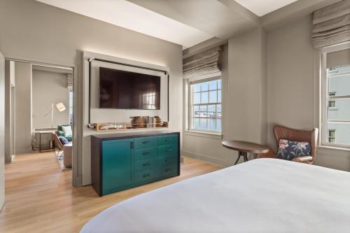 a bedroom with a blue dresser and a tv at Hotel Indigo Baton Rouge Downtown by IHG in Baton Rouge