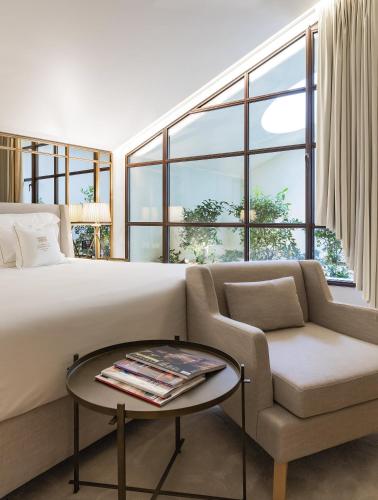 a bedroom with a bed and a couch and a chair at Casa da Companhia Hotel & Spa, Vignette Collection by IHG in Porto