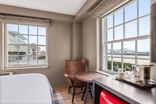 a room with a table and two windows at Hotel Indigo Baton Rouge Downtown by IHG in Baton Rouge