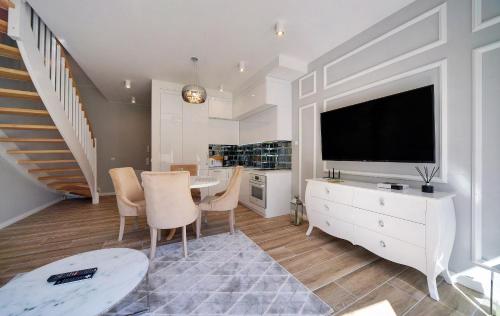 a living room with a table and a large television at Apartament Glamour in Pobierowo