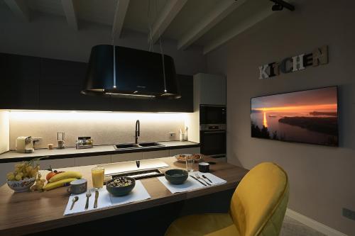 a kitchen with a table with a yellow chair and a counter top at Cavour 7 in Salò