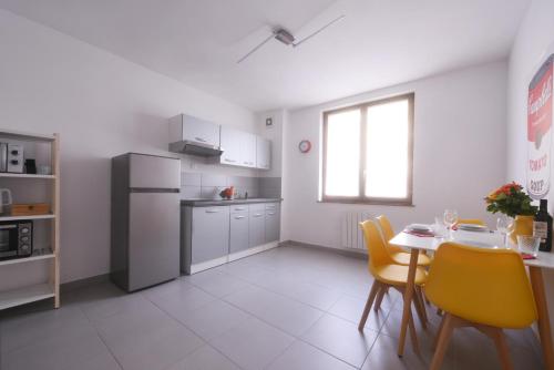 une cuisine avec une table et des chaises jaunes dans une pièce dans l'établissement Appartement Wahrol, à Bellegarde-sur-Valserine