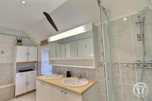 een badkamer met twee wastafels en een douche bij De dartagnan in Val Couesnon