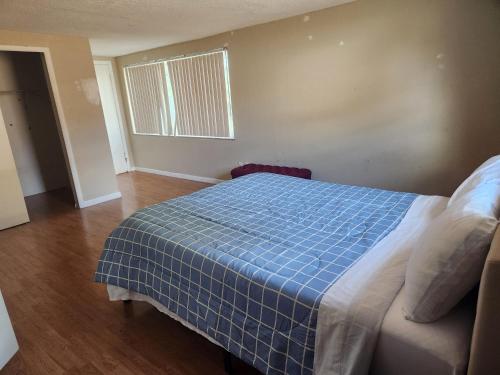 a bedroom with a bed with a blue checked blanket at Spacious cozy 3 bedroom waterfront house at port Richey in Port Richey