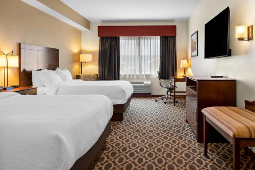 a hotel room with two beds and a desk at Best Western Paradise Inn in Savoy