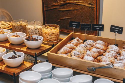 a display case with various pastries and other food items at DelleArti Design Hotel in Cremona