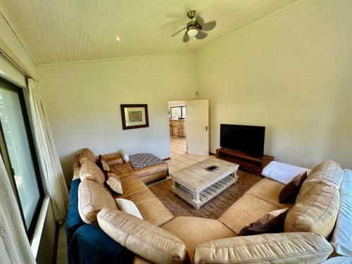 a living room with a large couch and a flat screen tv at Kangela 1 in Ponta Malongane