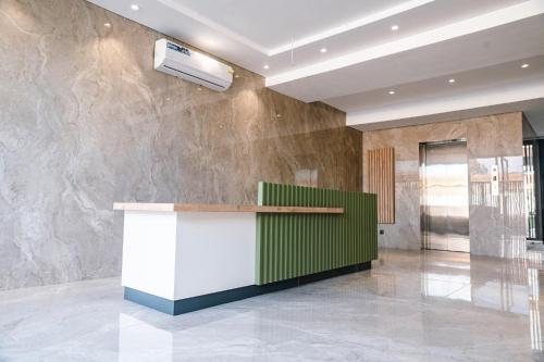 a lobby with a green and white counter and a wall at Luxury Studios by Home in Mpehuasem